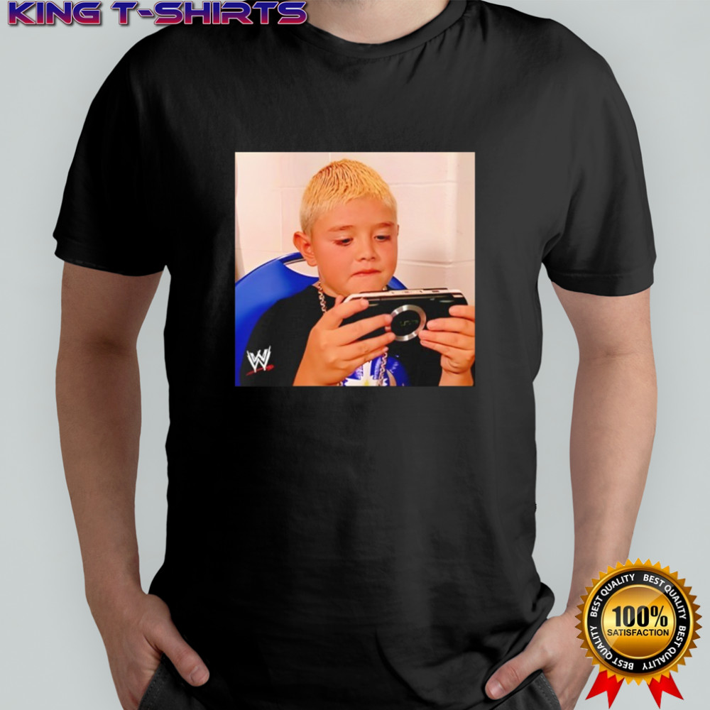 Dominik Mysterio wearing his younger self playing the PSP shirt